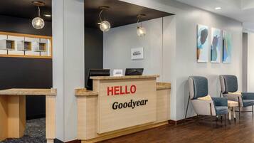 A reception desk with 'HELLO Goodyear' signage, a computer, and two chairs.