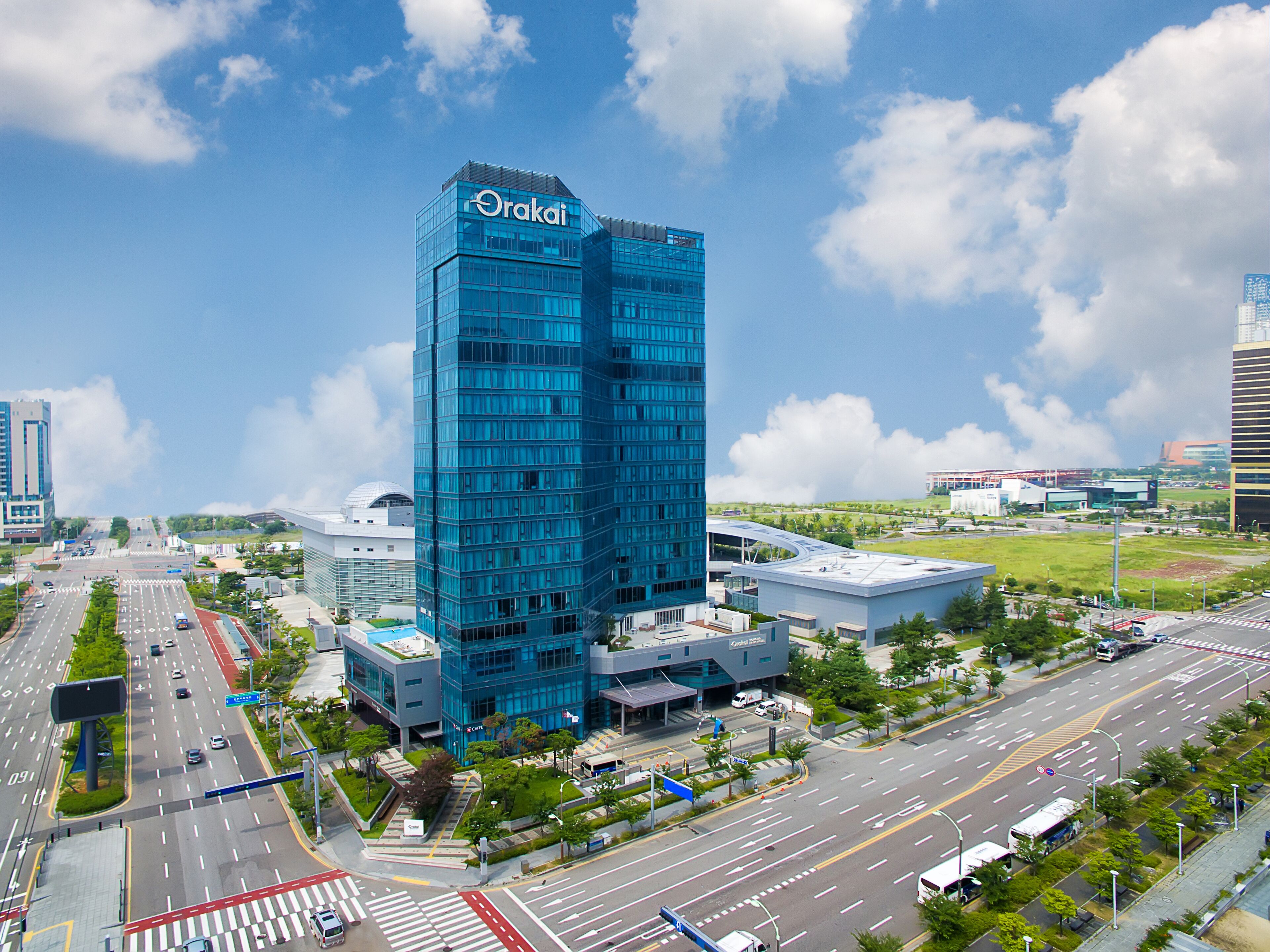 A modern high-rise building with a glass facade and the name 'Orakain' on the top.