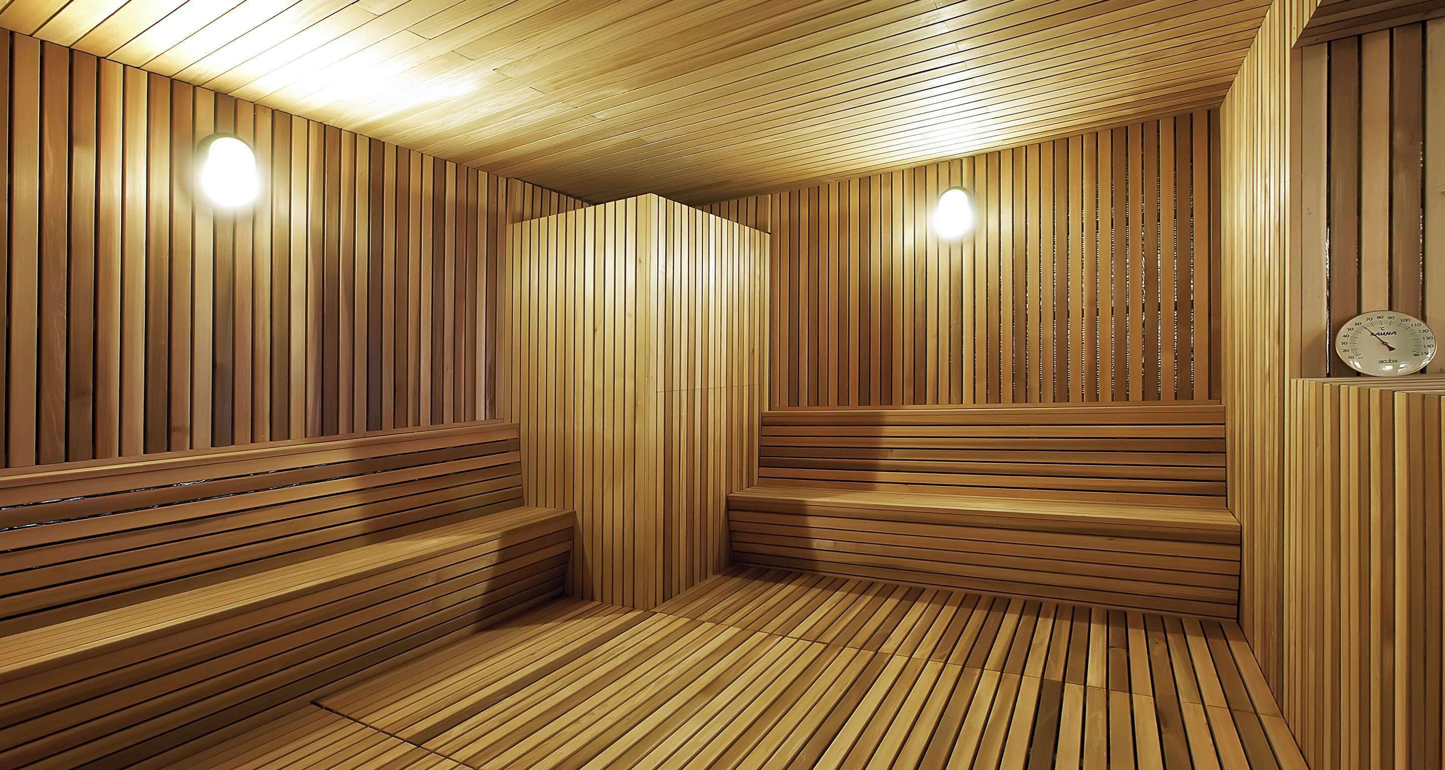 Un sauna avec des lambris en bois aux murs et des bancs en bois.