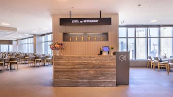 A reception area with a sign reading 'LEVEL 19 RESTAURANT' and a digital screen displaying 'Orakai'.