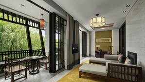 A modern hotel room with a large window, a sofa, a dining area with chairs, and a TV. - Banyan Tree Hangzhou (Hangzhou)