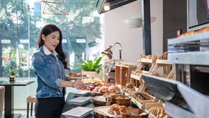 A buffet setup with various food items and a person serving. - Marriott Executive Apartments Sukhumvit Park, Bangkok (Bangkok)