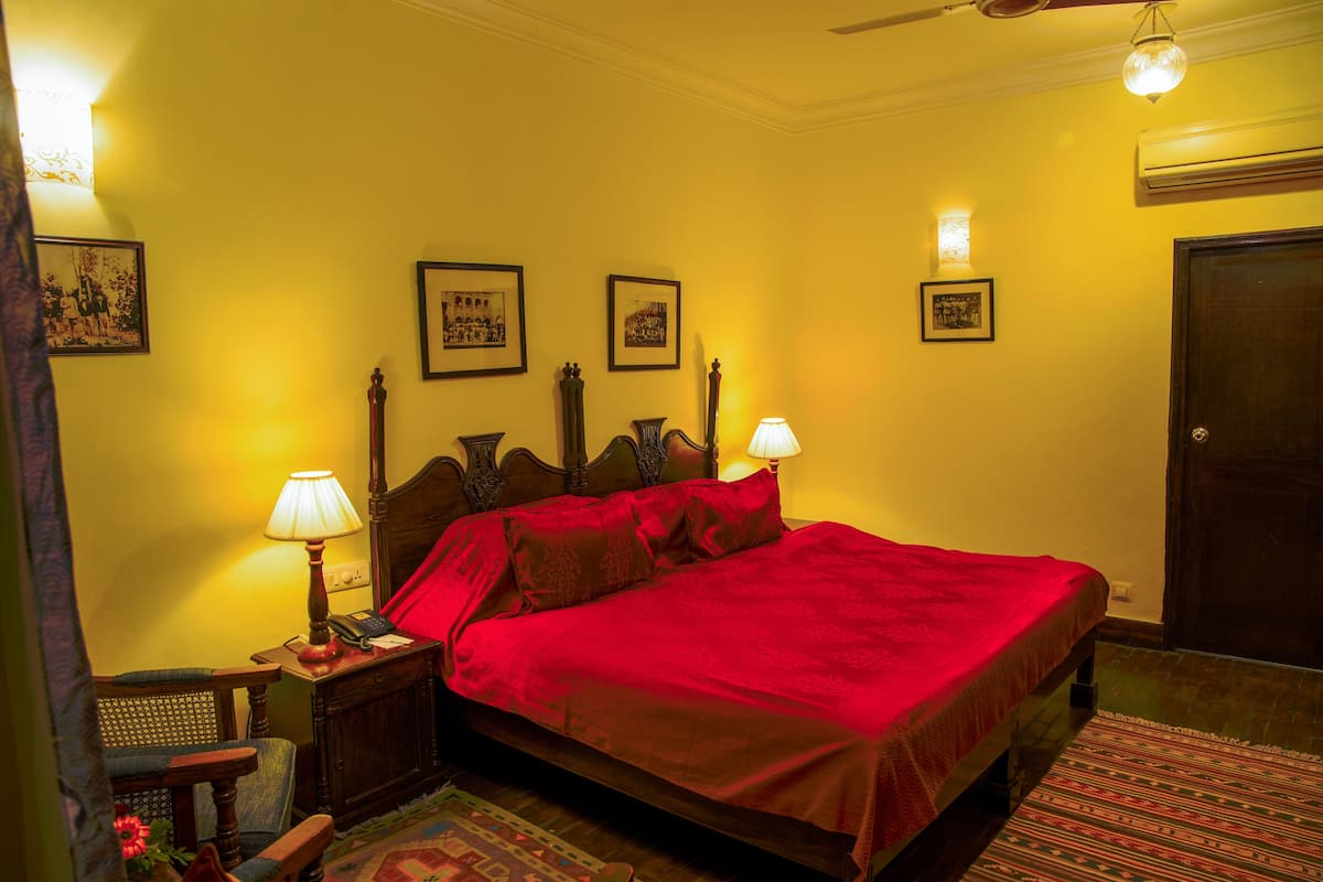 A bedroom with a bed, bedside lamps, a chair, and a rug.