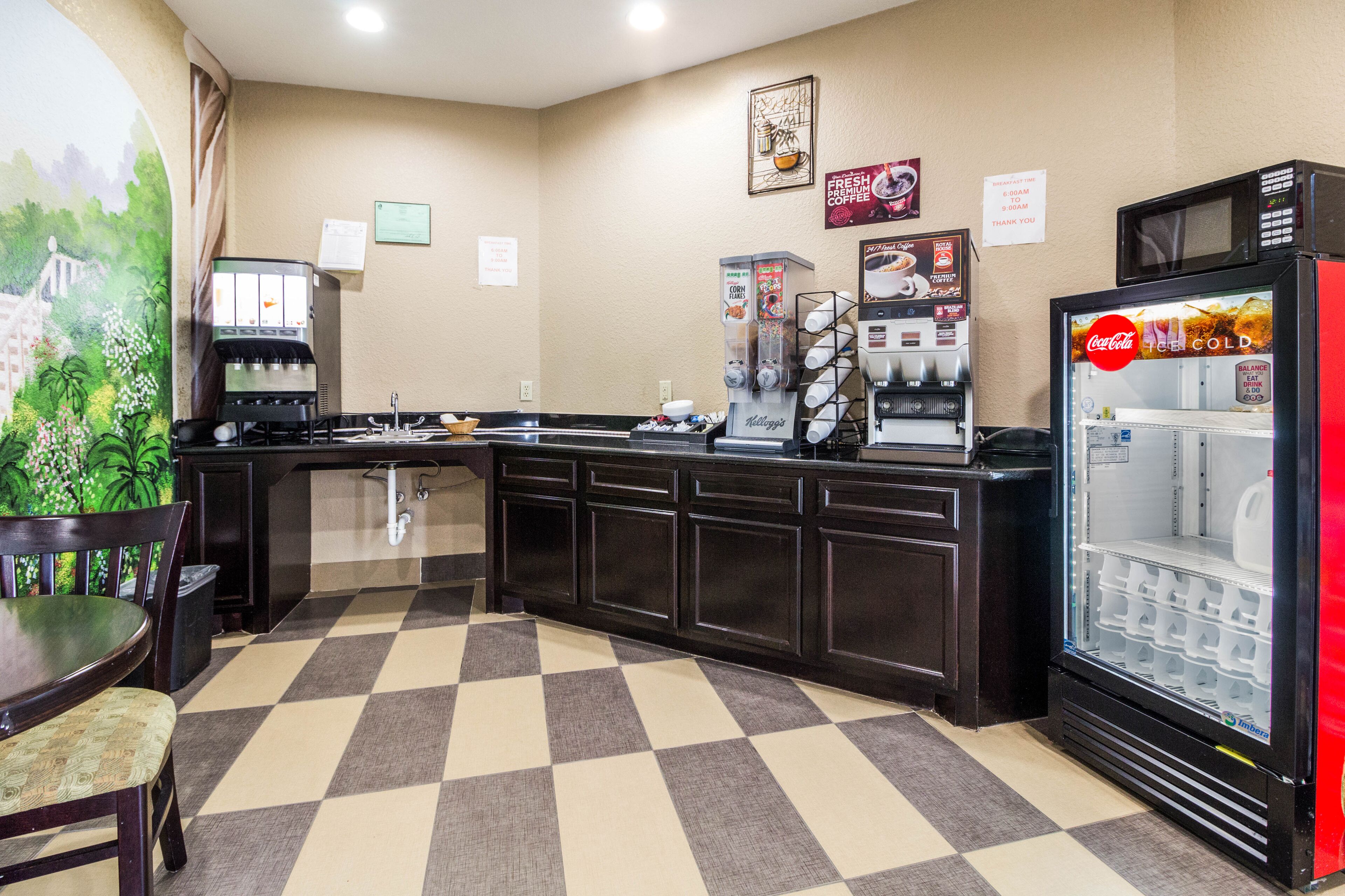 A hotel kitchen with a coffee machine, a refrigerator, and a microwave.