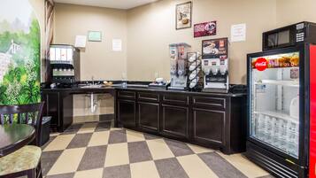 A hotel kitchen with a coffee machine, a refrigerator, and a microwave.