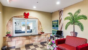 Ein Empfangsbereich mit einer Rezeption, einem roten Sofa, einem Blumentopf und einem Schild für Scottish Bank & Suites.