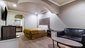 Ein Hotelzimmer mit einem Bett, einer Couch, einem Schreibtisch und einem Fernseher.