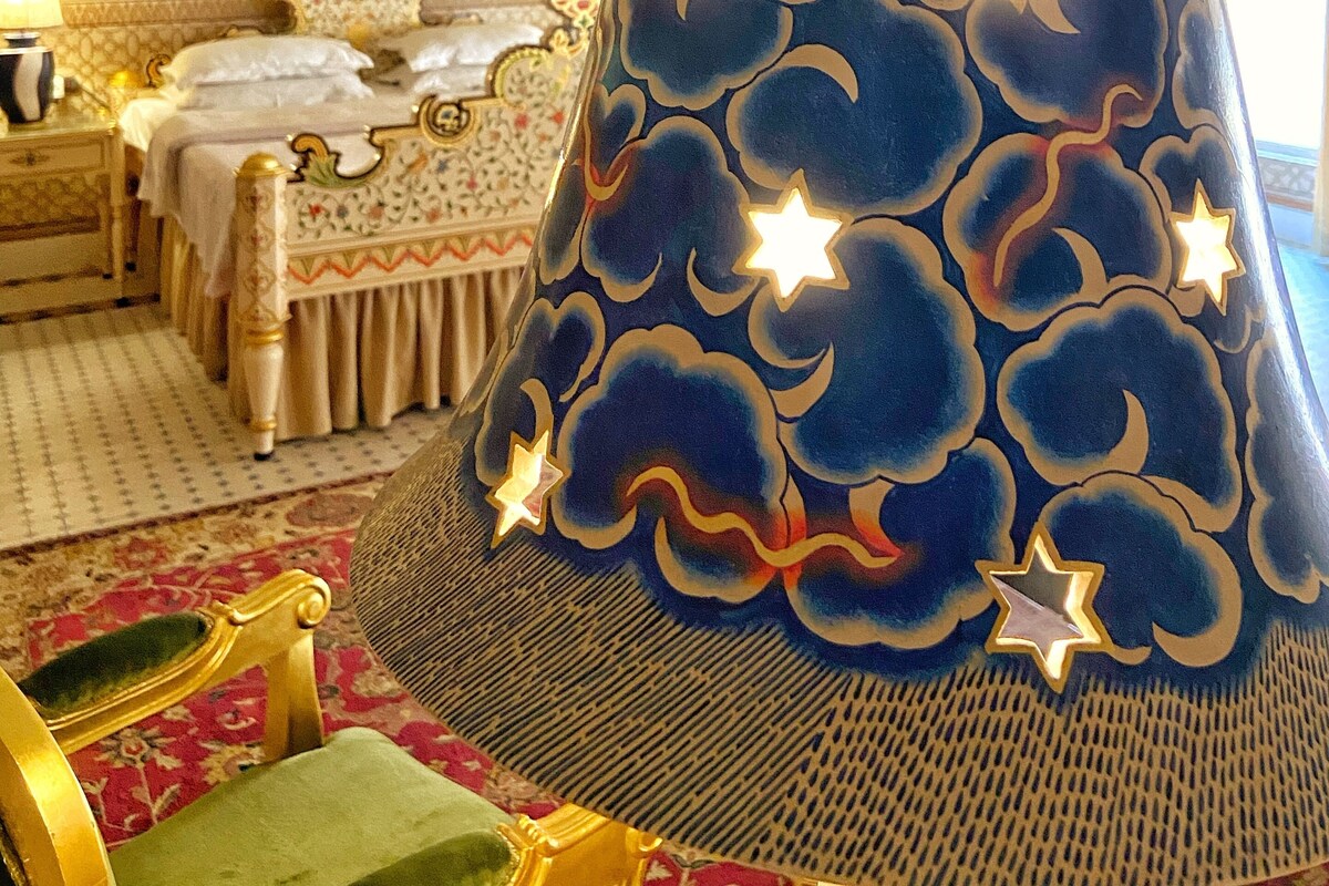 A room with a bed, a nightstand, a lamp, and a chair.