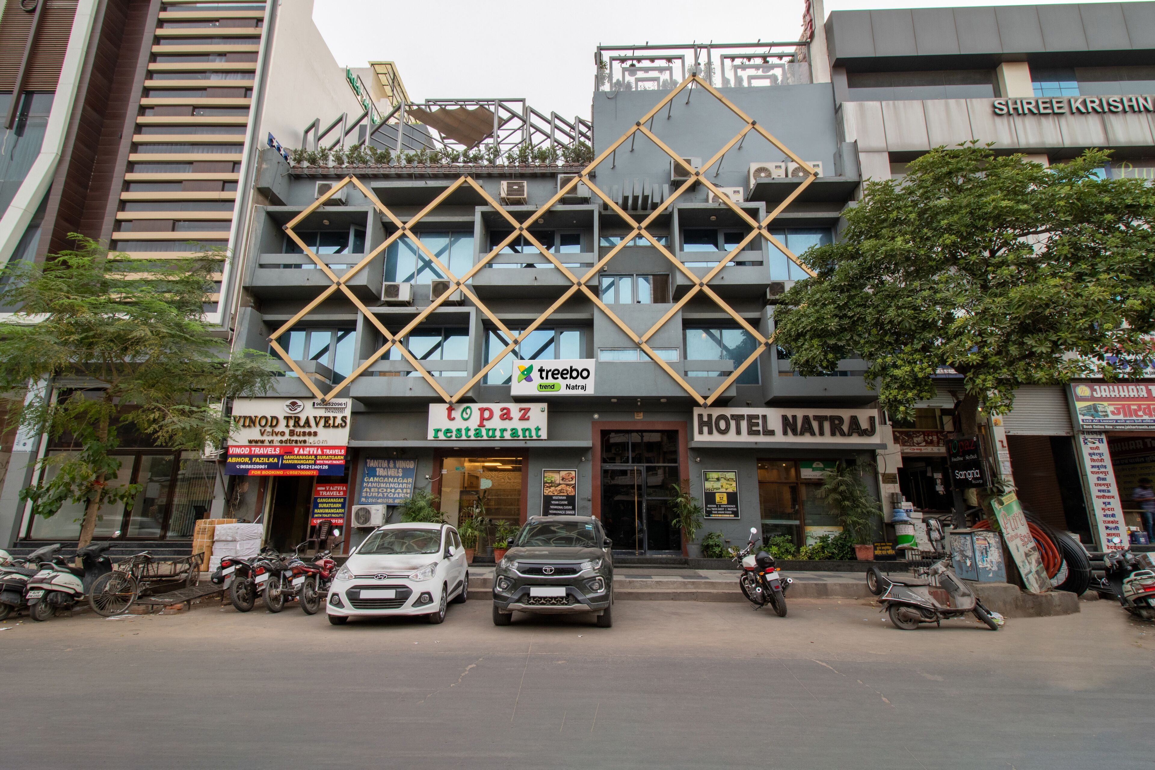 Un immeuble abritant plusieurs commerces, notamment un restaurant, un hôtel et une agence de voyages.