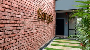A brick wall with the name 'Sangria' in gold lettering. - Treebo Natraj - Jaipur (Jaipur)