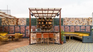 An outdoor patio with a bar area, seating, and a patterned floor. - Treebo Natraj - Jaipur (Jaipur)