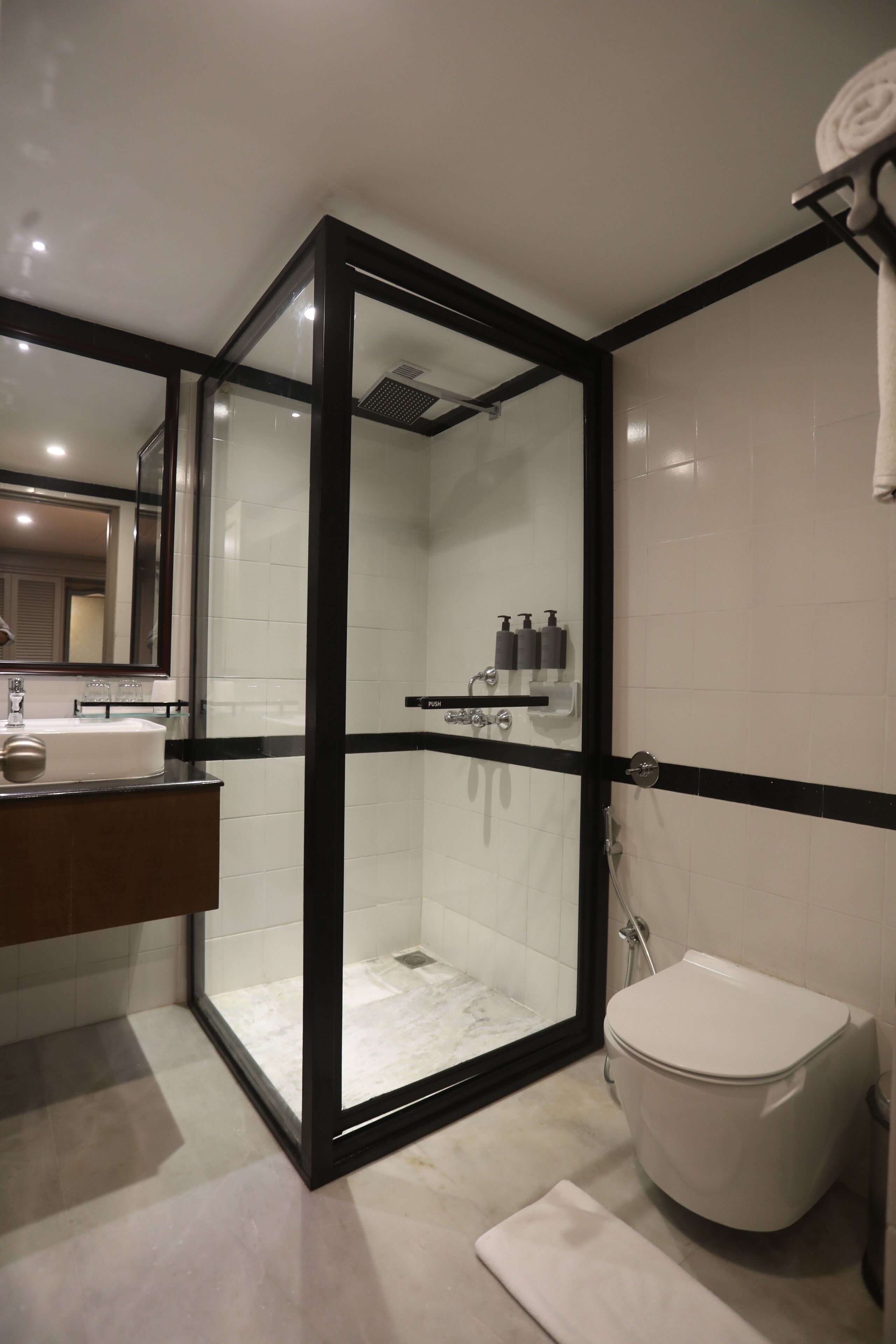 Une salle de bain moderne avec une douche à parois de verre, un lavabo blanc et des toilettes.
