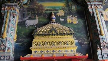 Un mural detallado con una cúpula central y columnas circundantes, que representa una escena rural con gente y animales.