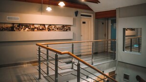 A modern interior with a staircase, wooden beams, and a wall-mounted picture.