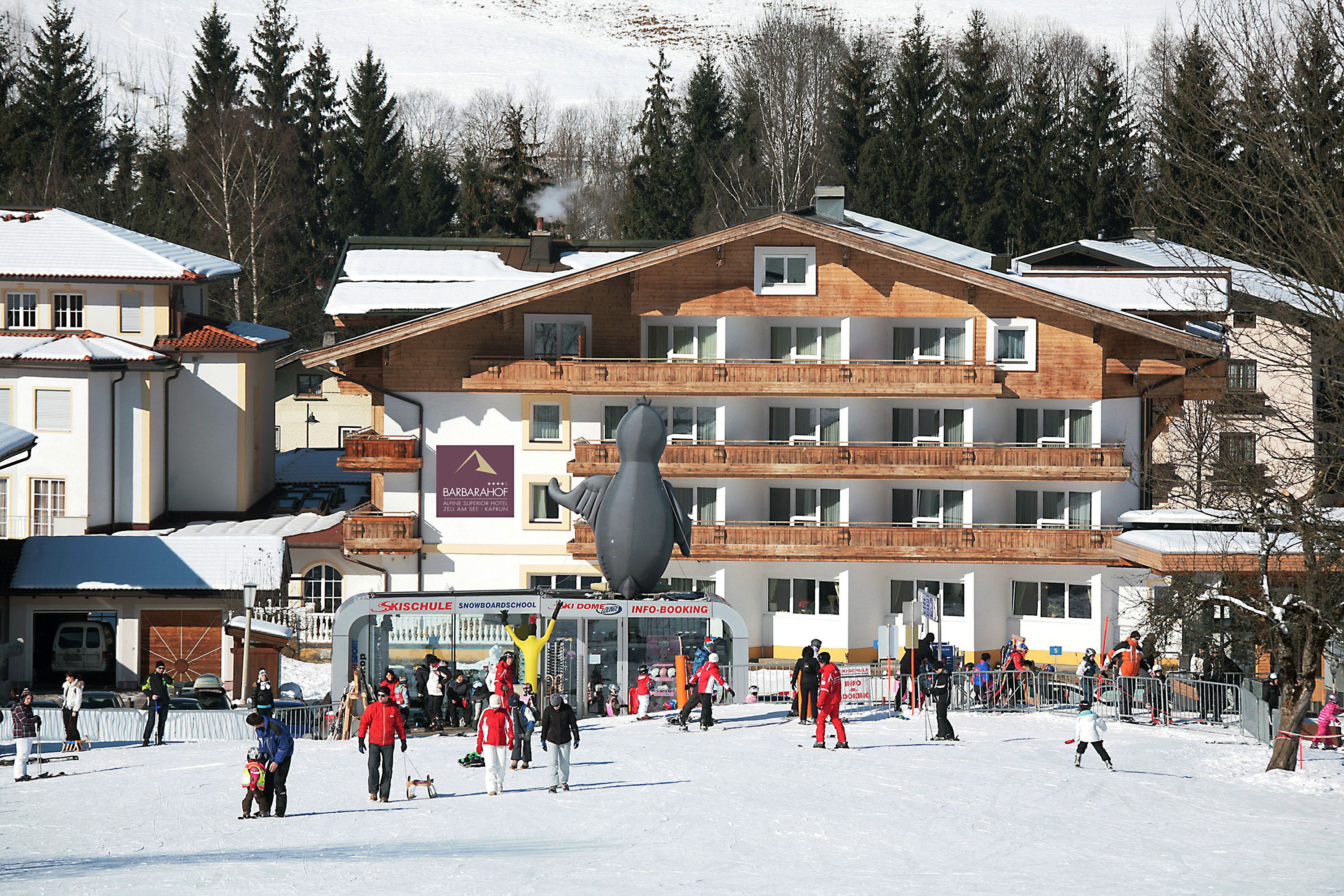 A ski resort with a large building featuring multiple balconies and a ski lift.