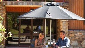 A two-story wooden building with a balcony and outdoor seating area. - Distinction Mackenzie Country Hotel (Twizel)