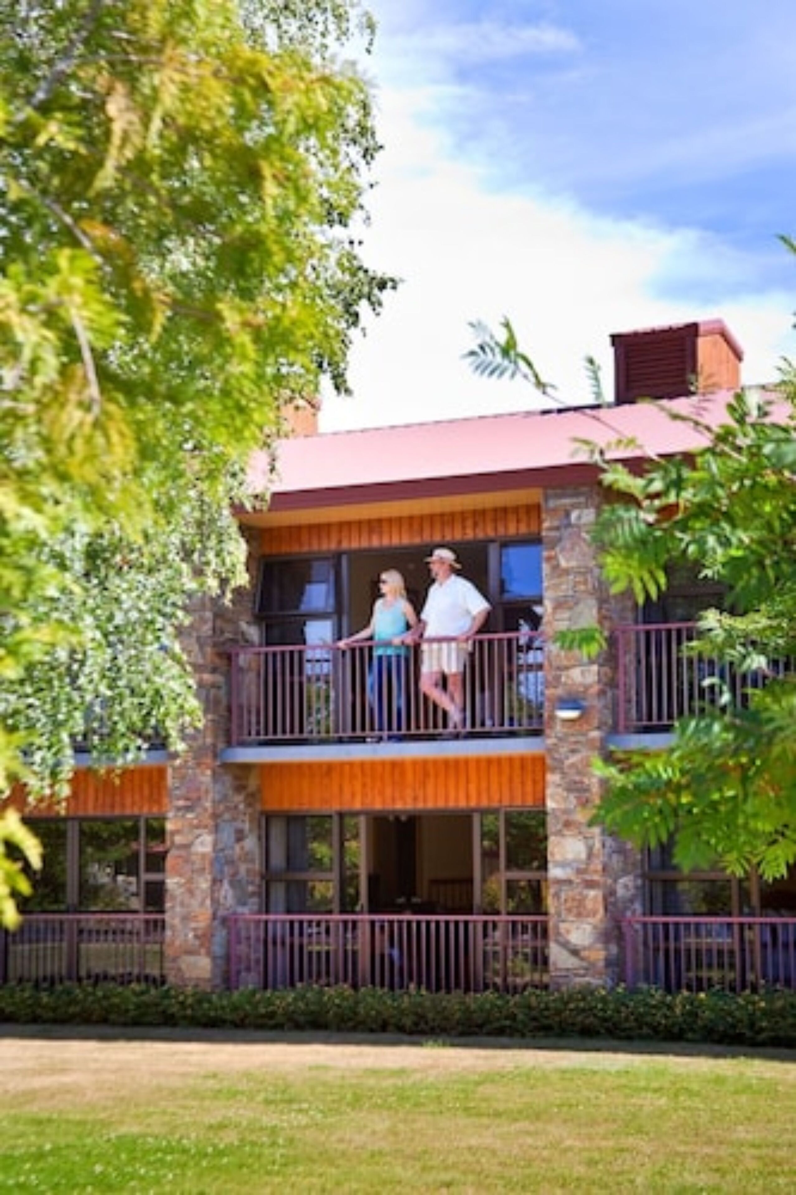 A two-story building with a stone facade and a balcony.