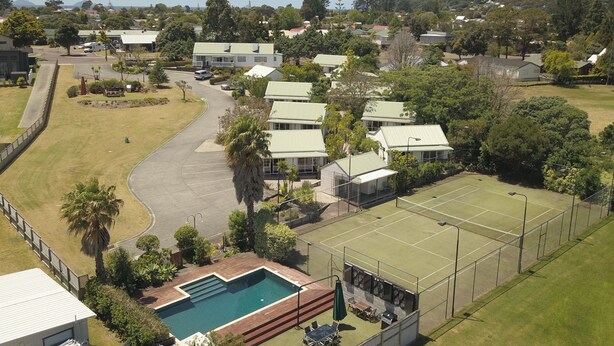 Zona residencial con casas, cancha de tenis y piscina.
