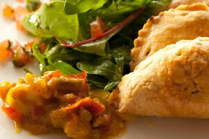 A plate with a baked dish, possibly chicken, and a side salad.