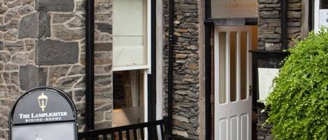 A stone building with a sign for The Lamplighter Dining-Rooms.