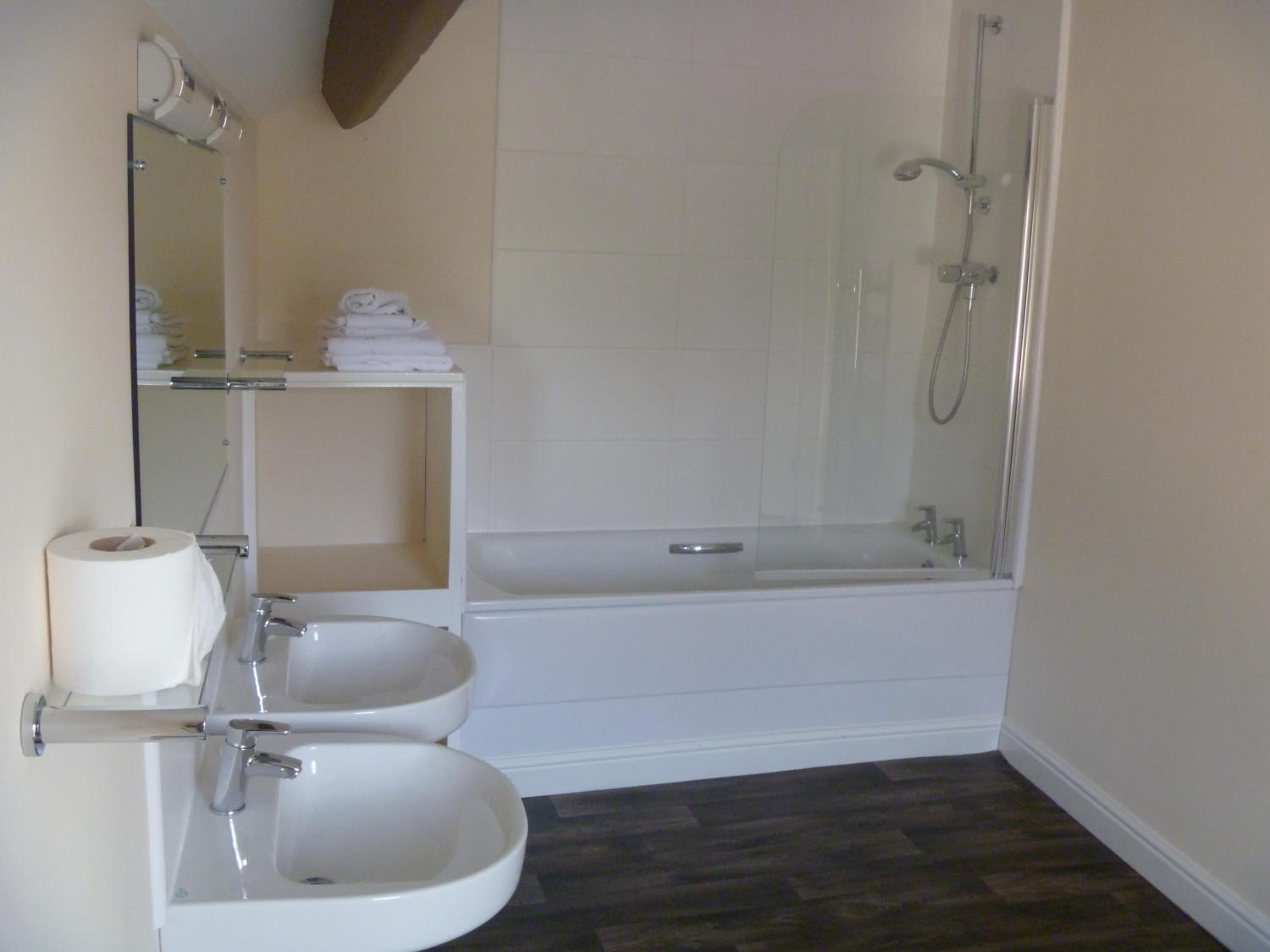 A bathroom with two sinks, a toilet, a bathtub, and a shower.