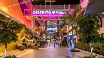 Ein hell erleuchtetes Einkaufszentrum mit einer großen, beleuchteten Schilder, auf denen "DISTRITO T-Mobile" steht.