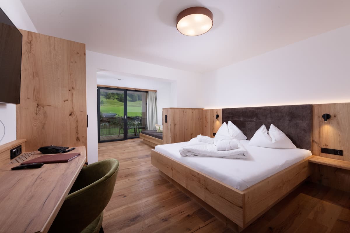 A modern bedroom with a wooden bed, a desk, and a chair.