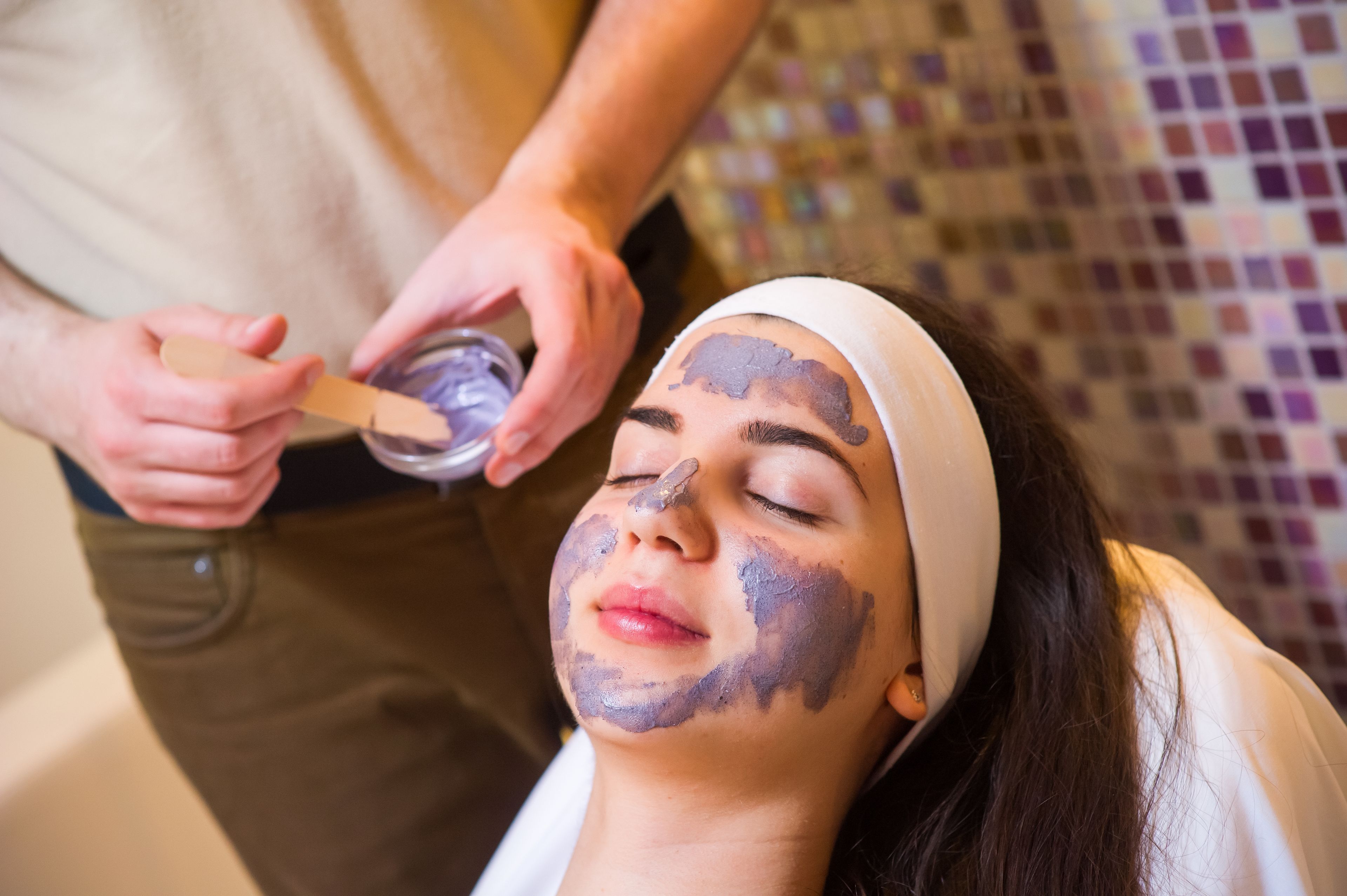 A person receiving a facial treatment with a facial mask.