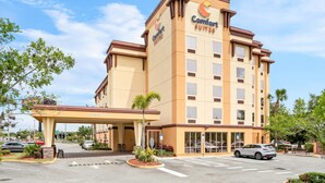 Ein Comfort Suites Hotel mit freiem Zugang, einem überdachten Parkbereich und einer gepflegten Fassade.