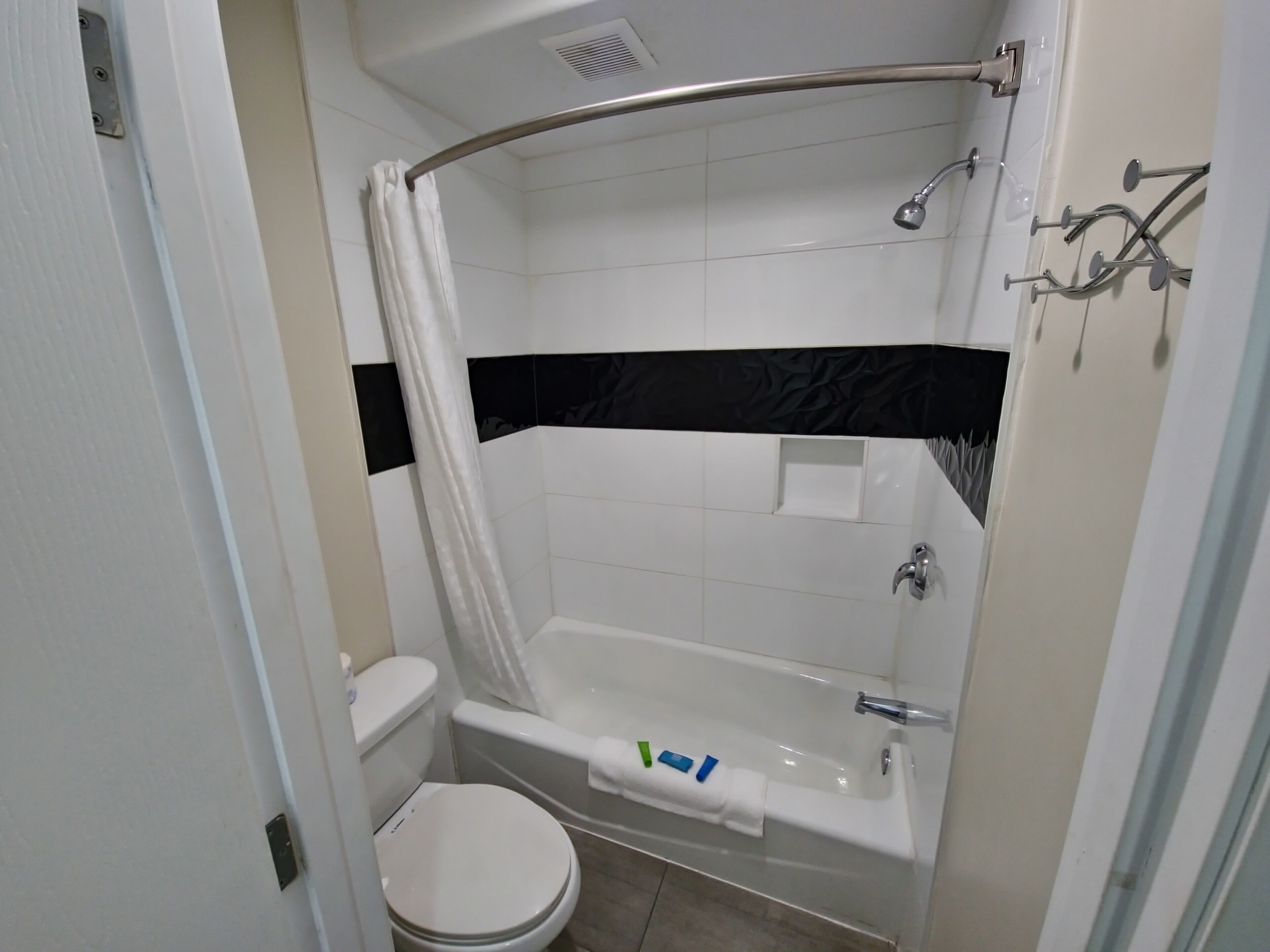 A bathroom with a white bathtub, a shower, and a toilet.
