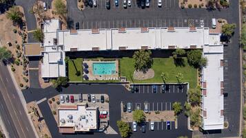 Vista aérea de un hotel con piscina, estacionamiento y zonas ajardinadas.