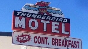 A motel sign with a thunderbird logo and a sign for free continental breakfast.