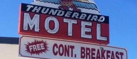 Letrero de motel con el logotipo de un cóndor y anuncio de desayuno continental gratuito.