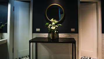 Una habitación con una mesa negra, un espejo redondo y una puerta blanca.