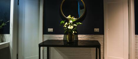 A room with a black table, a round mirror, and a white door.