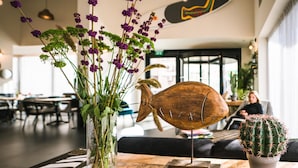 A wooden table with a cactus, a fish sculpture, and a vase with purple flowers. - Roxon Sea Sand Bat Yam (Bat Yam)