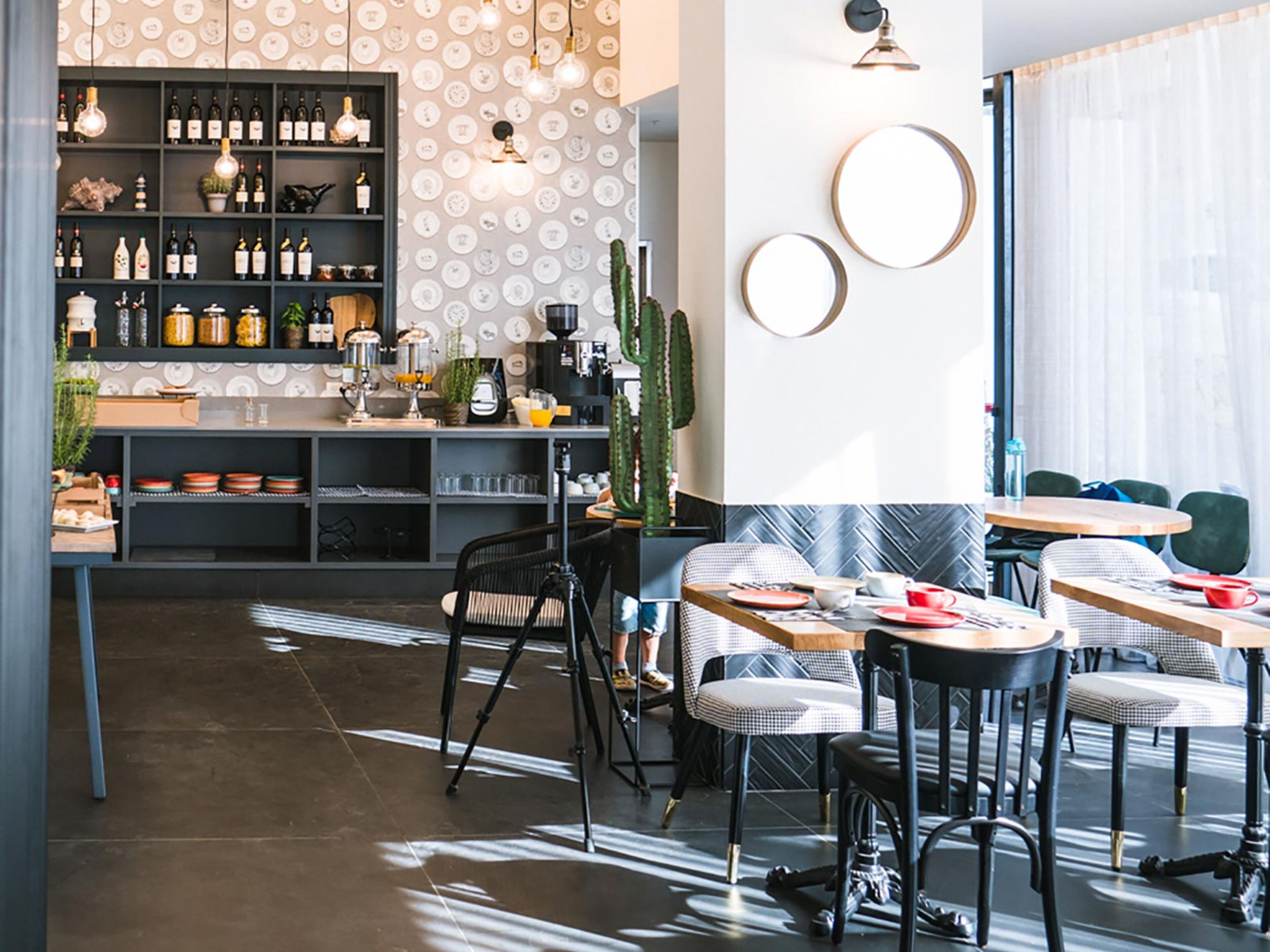 Un café moderne doté d’un bar, de coins salon et d’un mur orné de motifs.