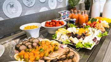 Un bufé con diversos alimentos, como frutas, verduras y carnes.