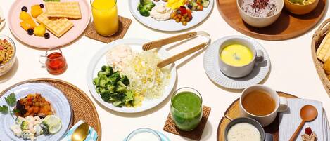A table set with various dishes, including waffles, fruit, and soup, suggesting a breakfast or brunch setting.