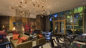 A modern lounge with a central seating area, a bar, and large windows offering a view of the outdoors. - InterContinental Shanghai Jing’ An by IHG (Shanghai)
