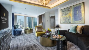 A modern hotel room with a city view, a large abstract painting, and a mix of seating options including a sofa, armchairs, and a round coffee table. - InterContinental Shanghai Jing’ An by IHG (Shanghai)