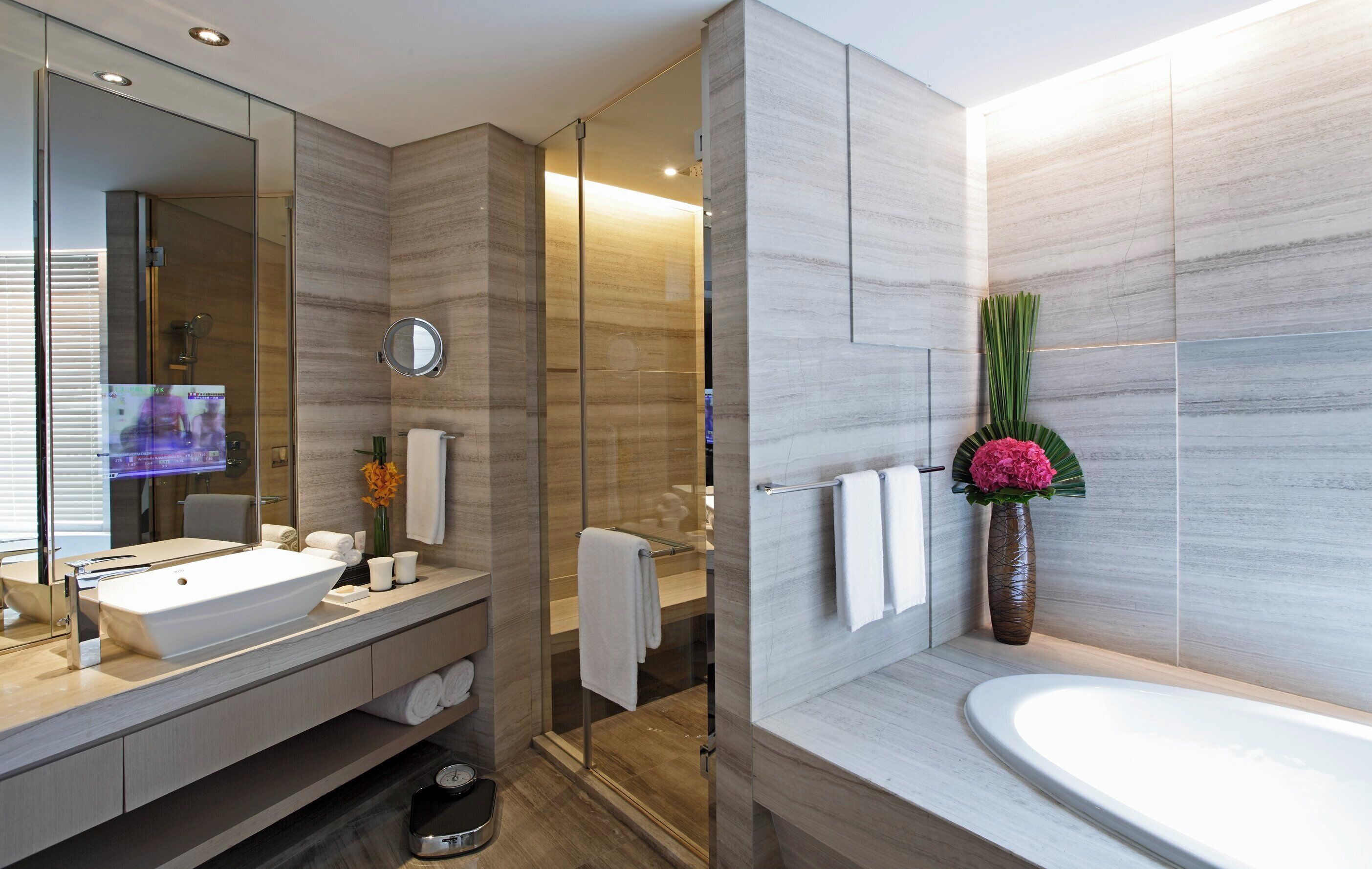 Un baño moderno con un lavamanos grande, un espejo y una bañera.