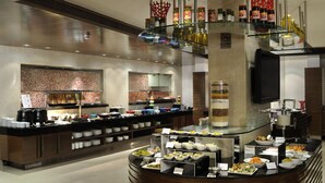 A buffet setup with various food items and condiments.