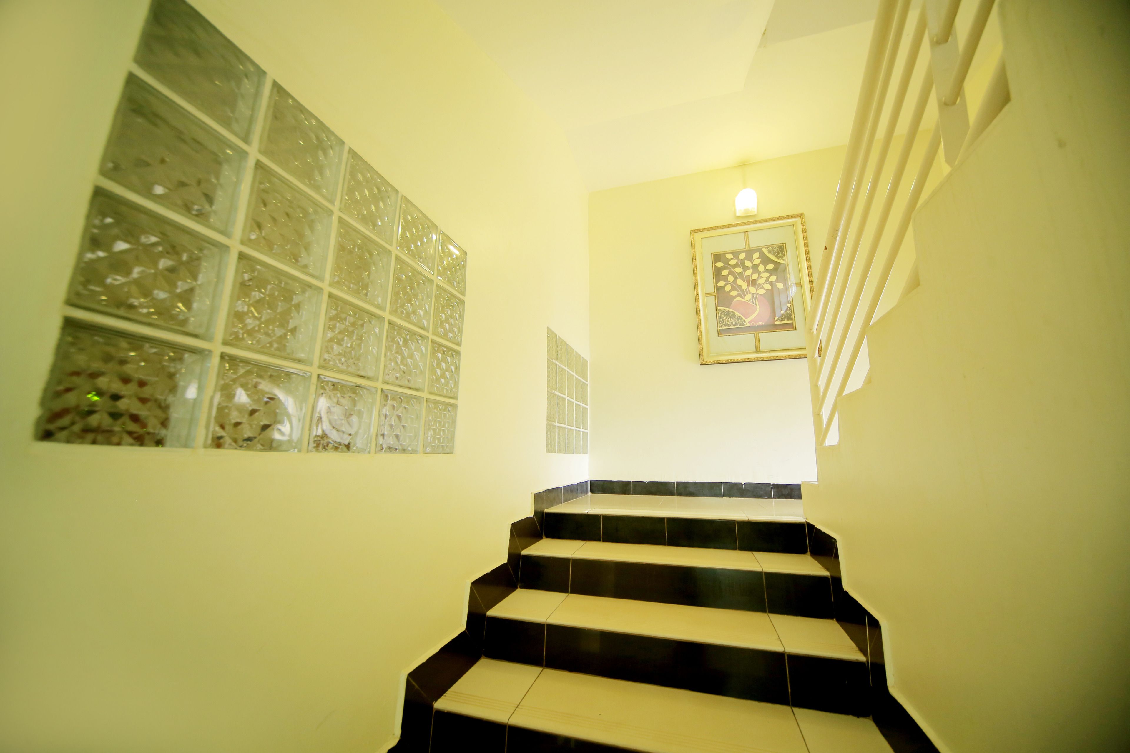 A staircase with black and beige steps leading to a landing.