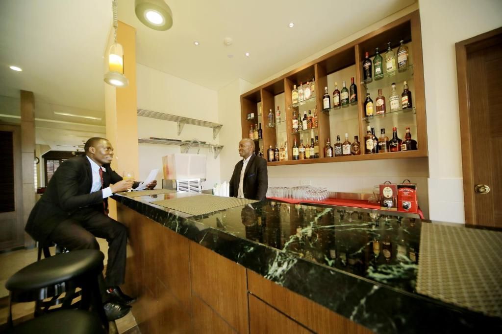 A bar area with a marble countertop and shelves stocked with liquor bottles.