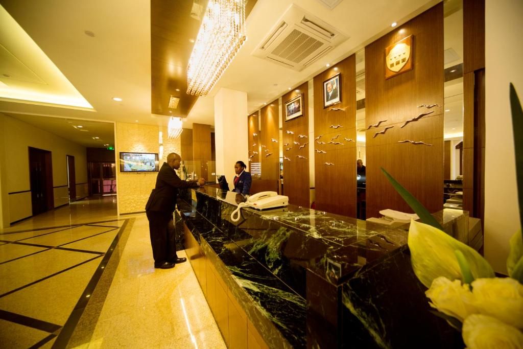 A hotel reception area with a marble counter, a telephone, and a television screen.