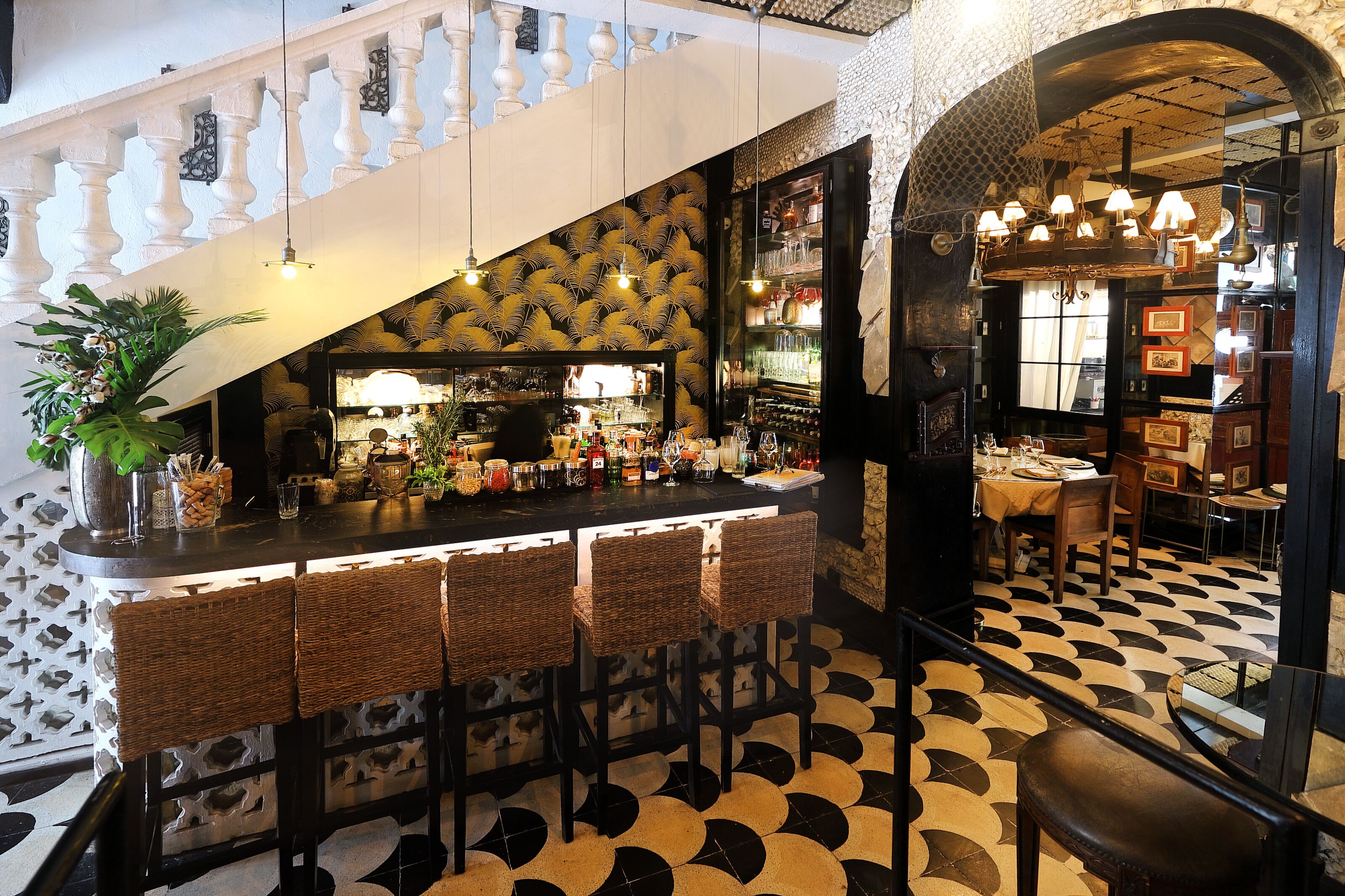 A bar area with a counter, bar stools, and a patterned floor.