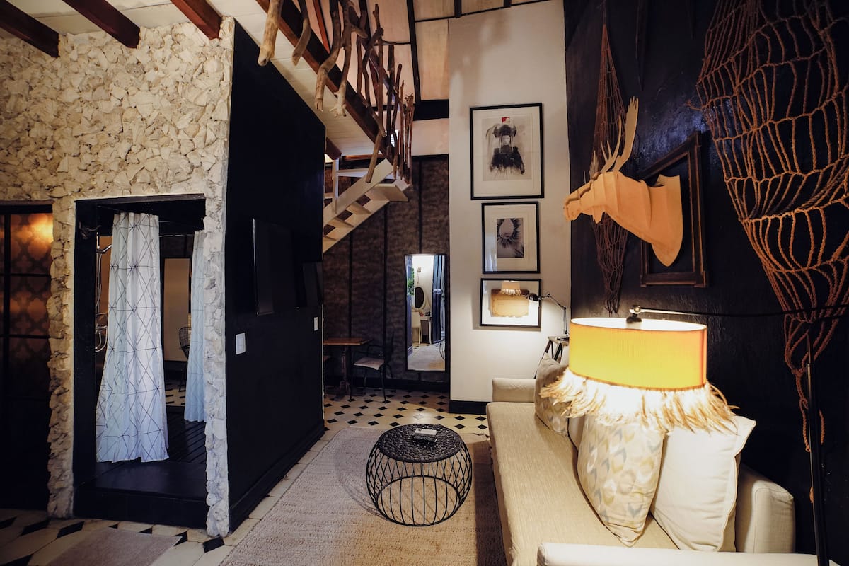 A cozy living room with a staircase, a fireplace, and a dining area.