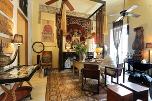 Un interior tradicional con comedor, ventilador de techo y suelo estampado.
