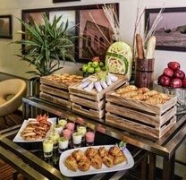 A buffet table with various food items, including pastries, fruits, and beverages.